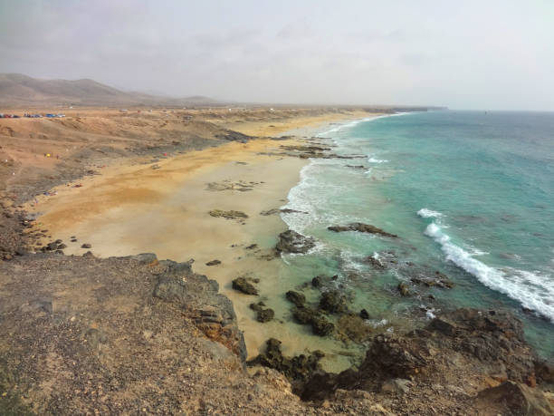 Scenic view of the beautiful yellow sand beach with some black volcanic rocks on Fuerteventura island, Canary Islands, S stock photo