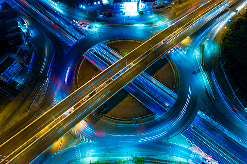 Expressway top view, Road traffic an important infrastructure,car traffic transportation above intersection road in city night, aerial view cityscape of advanced innovation, financial technology