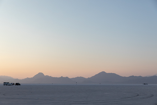 Car on top of the Bonneville Salt Flats in Utah at sunset in United States, Utah, Wendover