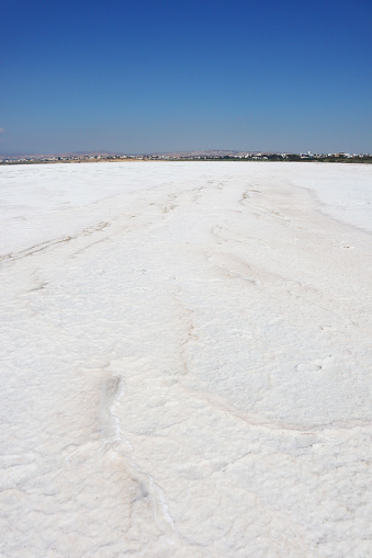 Big white salt lake view from the middle of the dried up lake on a sunny, hot day while the lake bed having shiny white salt crystals