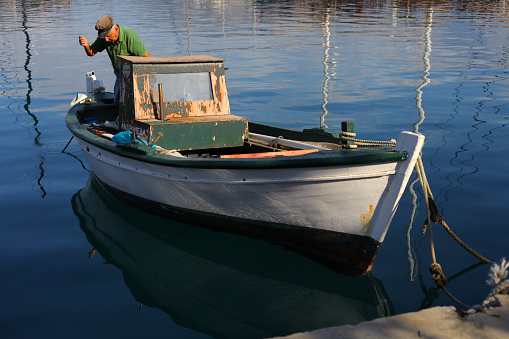 Kefalonia, Greece - September 04, 2014: Smiling fishermen with little fish at morning, Sami harbor, Kefalonia island, Ionian Sea, Greece