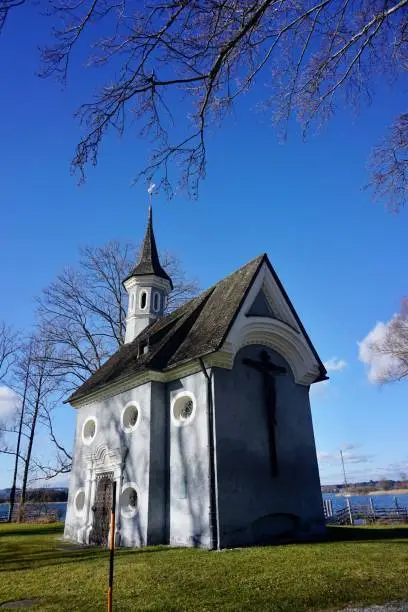 The small chapel is located opposite the Urfahrn Peninsula. King Ludwig II went from there by boat to the Herreninsel when he wanted to visit the construction site of his little Versailles and landed right here at the church, from where he was then driven to the castle in a carriage.
