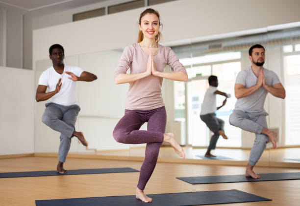 istock Woman doing yoga postures on group training 1418057589