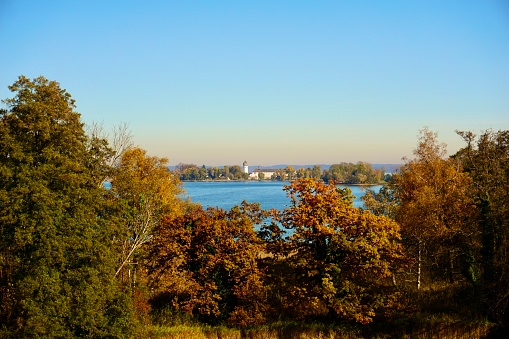 Autumn on Lake Chiemsee. Smooth alleys of trees, paths dusted with autumn foliage. Colors of autumn.