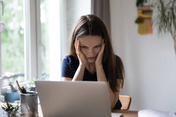 istock Stressed shocked young woman frustrated about problems with laptop 1418063636
