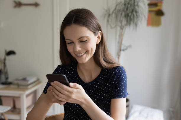 istock Happy beautiful millennial girl engaged in using mobile phone 1418063646