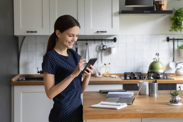 istock Happy focused gadget user girl browsing Internet on mobile phone 1418063661