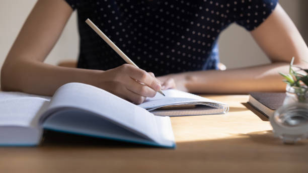 Young student girl preparing for college test, exam, writing notes stock photo