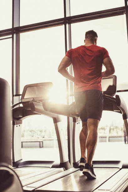 istock Young athletic man running on a treadmill as the sun is setting 1418064365