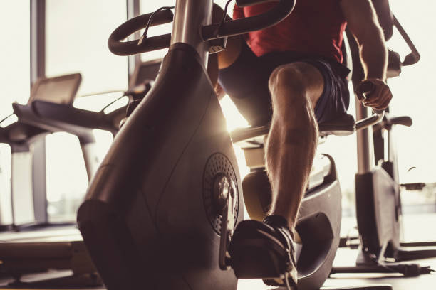 istock Unrecognizable male athlete using exercise bike at the gym 1418064369