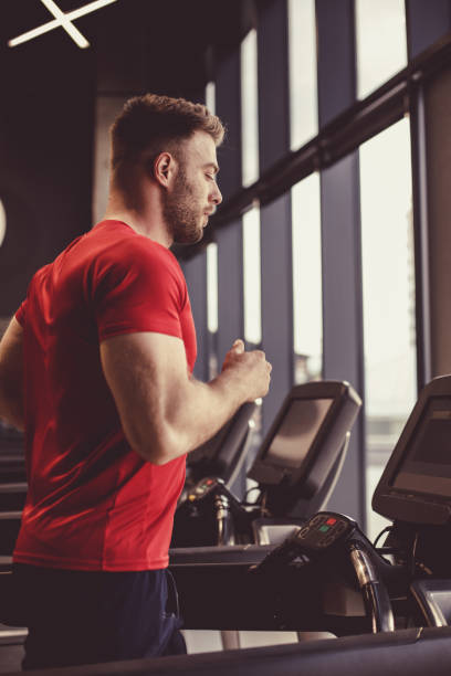 istock Male athlete warming up on a treadmill before a workout 1418064377