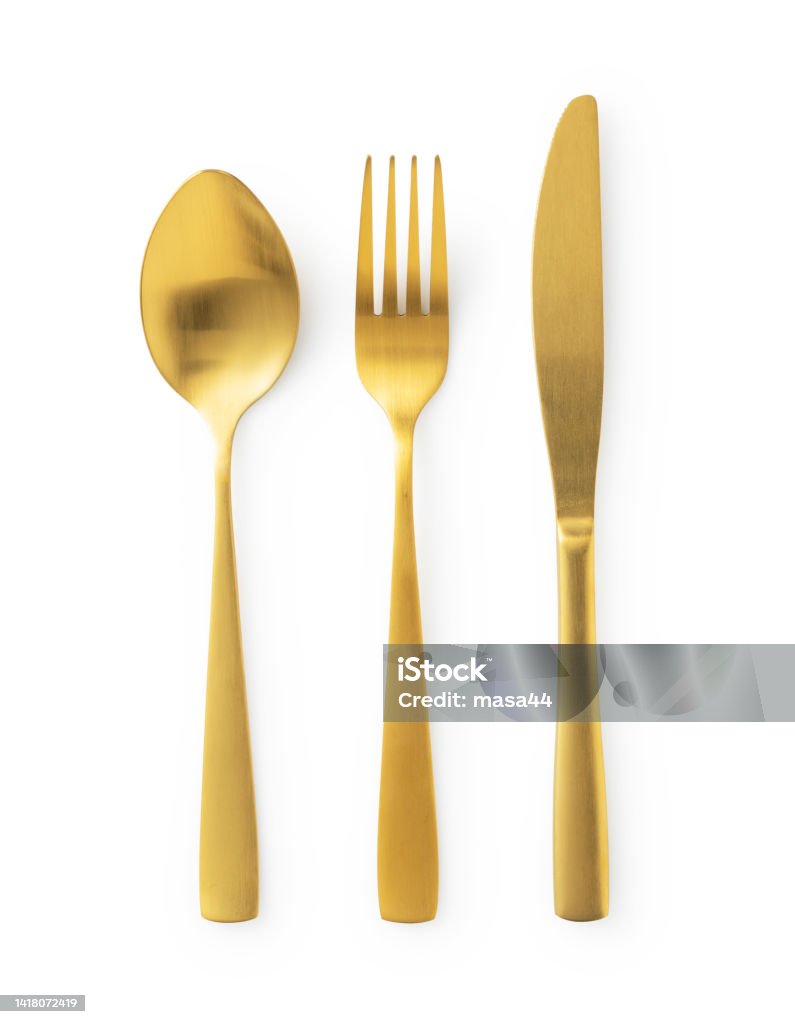 Gold knives, forks and spoons placed on a white background. Beautiful gold cutlery. Gold knives, forks and spoons placed on a white background. Beautiful gold cutlery. View from above. Fork Stock Photo