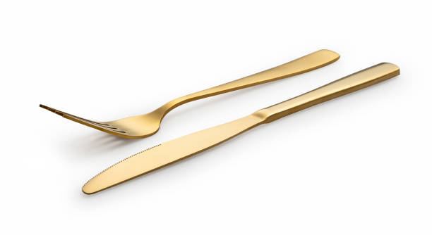 istock Gold knives and forks set against a white background. 1418072476
