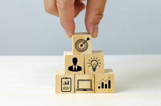 istock business strategy Action plan Goal and target icons with hand stack a wood cube block on a table. Copy space company development concept. 1418075723