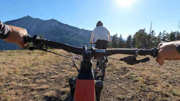 istock POV as mountain biker follows friend down trail 1418081765