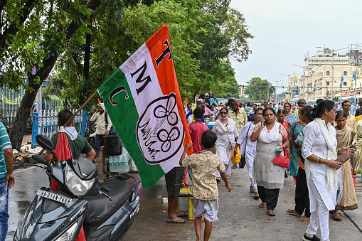 Kolkata, West Bengal, India - 21st July 2022 : All India Trinamool Congress Party, AITC or TMC, at Ekushe July, Shadid Dibas, Martyrs day rally. Party supporters arriving on sccoters with party flag.