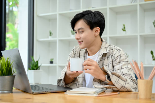 istock Male freelancer or office employee at his desk, sipping coffee while working on his project 1418085930