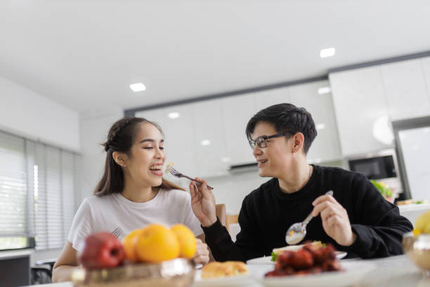 istock Asian Couple Having Breakfast Sitting In Kitchen, And bakery together happily. 1418087077