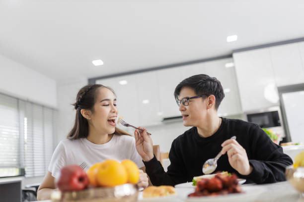 istock Asian Couple Having Breakfast Sitting In Kitchen, And bakery together happily. 1418087079
