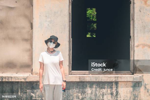 Woman Taking Photo With A Creepy Dark Windows Of An Abandond House Stock Photo - Download Image Now