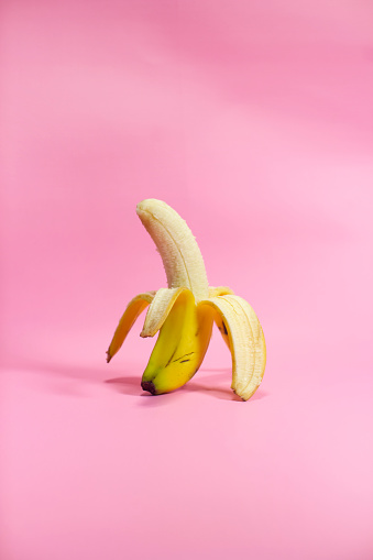 Half peeled Banana, Open Banana isolated on pink background.