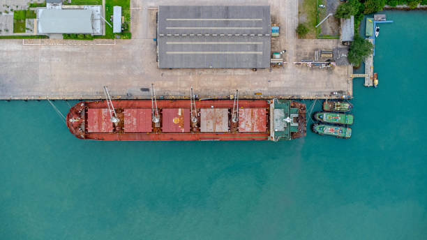 istock Aerial view from drone of commercial ship with cranes while unloading containers to large commercial ship in the wharf. Transportation and travel background, beautiful sea in summer. 1418104967