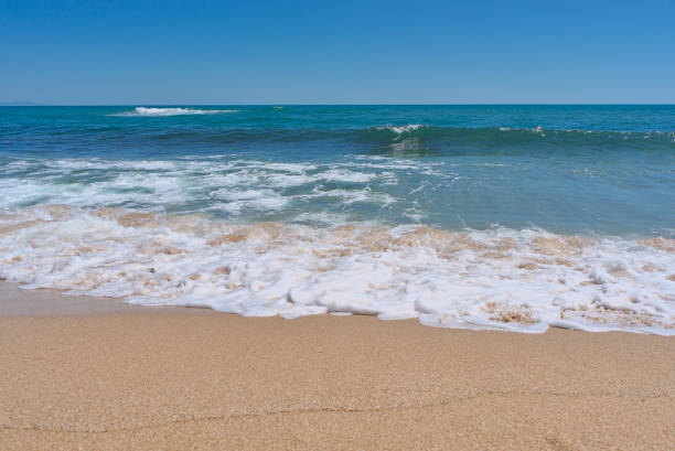 istock Clear emerald green sea with white foam and clean sandy beach 1418106309