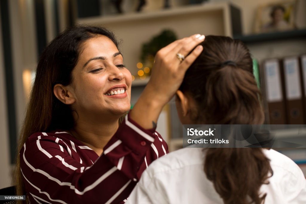 Mother getting her daughter ready in school uniform at home Loving mother getting her daughter ready for school at home Bonding Stock Photo