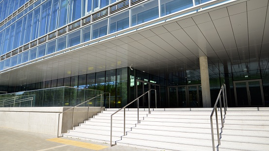 A mature black man wearing formal businesswear on a summers day in a city. He is walking up stairs as he sustainably commutes to work.