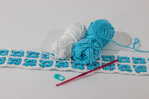 Close-up of hands doing crochet with yellow wool viewed from a high angle view