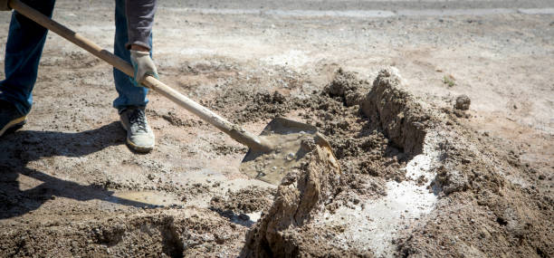 istock Worker prepare concrete with shovel at construction site. 1418114913
