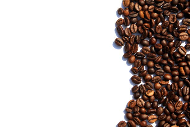 Coffee beans are scattered over a white isolated background.