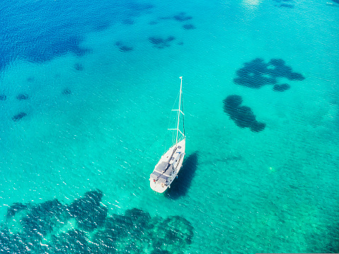 Aerial view of the sailing ship next to the Black Cenote in Bakalar.\nThe red kayak is moored to the boat
