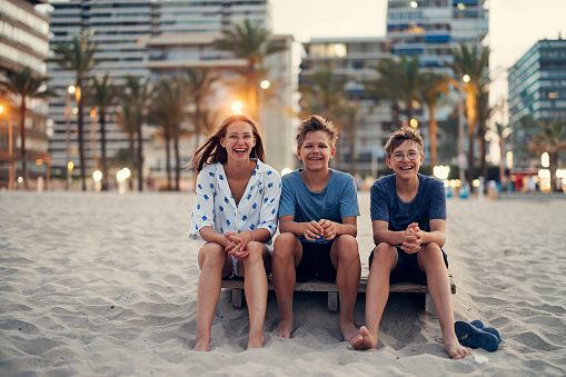 Three teenagers enjoying vacations in Alicante. They are sitting on the beach wooden deck.
Sunny summer evening in Alicante, Spain.
Canon R5