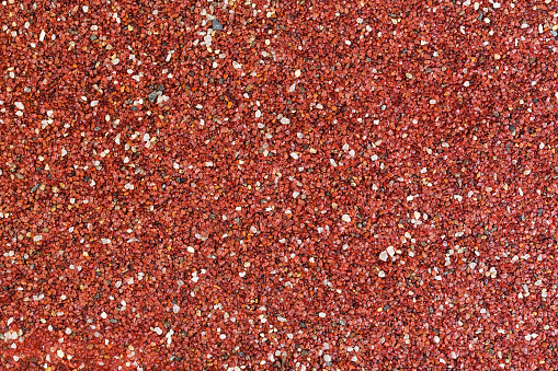 Texture of surface covered with small red stones.