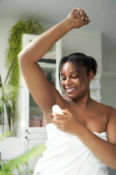 istock African-American woman feeling fresh while applying roll on antiperspirant 1418120321