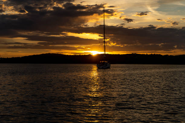 istock boat in the distance while the golden sun goes down 1418124790