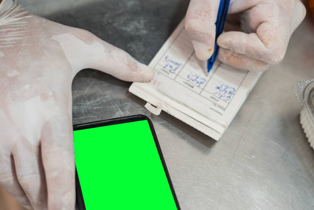 istock employee is writing the bill to mobile phone at workbench in restaurant 1418126705