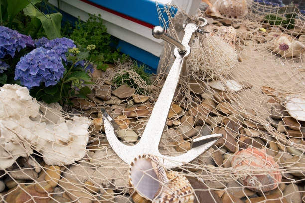 istock Anchor, fishing net, sea pebbles and shells close-up. 1418127510