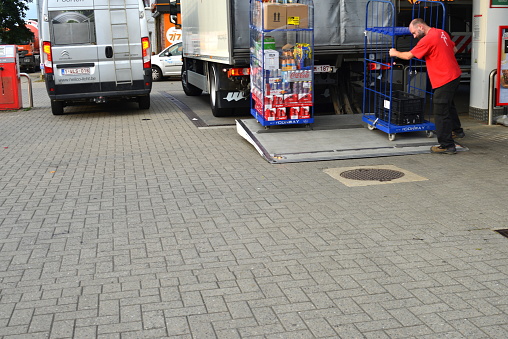 Wilsele, Vlaams-Brabant, Belgium - August 26, 2022:  Conway food service truck delivering snacks and drinks for Carrefour Express gas station shops at the Lukoil petrol stations. Driver holding a delivery trolley backside truck