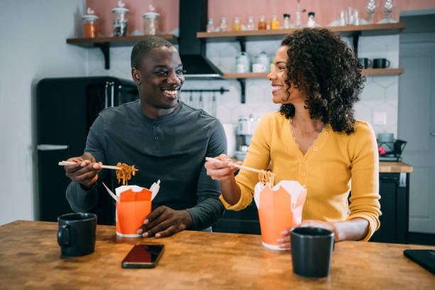 istock Smiling couple having lunch together at home. 1418128042