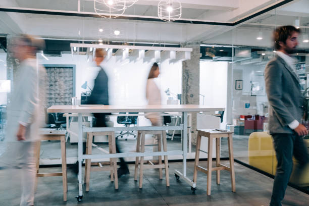 istock Modern office interior with blurred business colleagues. 1418128090