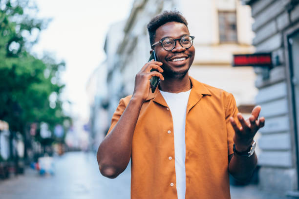 istock Cheerful young man talking on mobile phone in the city. 1418128134