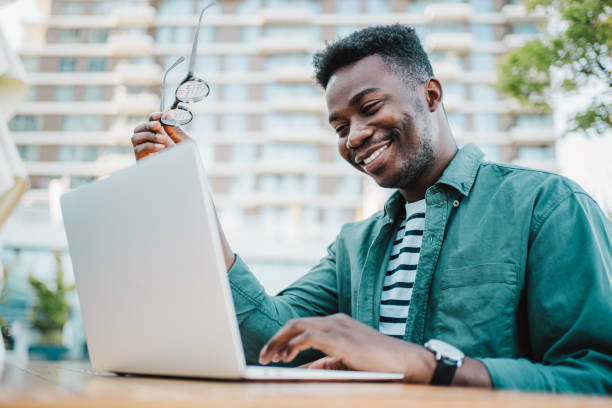 istock Young man sitting in coffee shop and using laptop. 1418128145