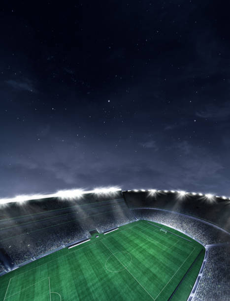 Aerial view of empty football field with flashlights and dark night sky background. Stadium with filled stands with sports soccer fans. stock photo