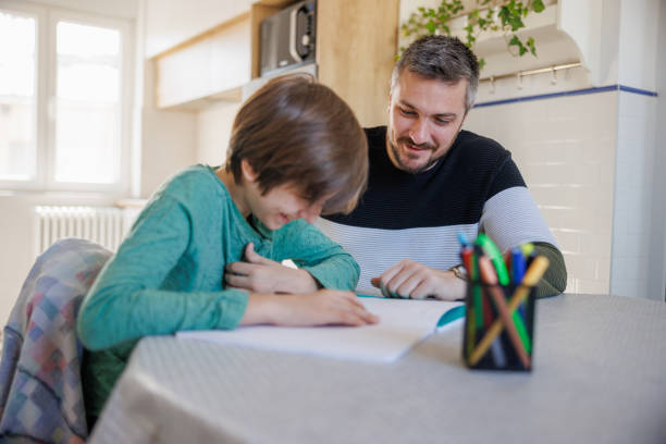 istock Home-schooled boy reading a subject from workbook, tutor listening and smiling 1418133899