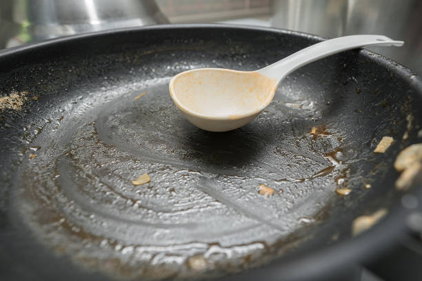 istock Dirty fat frying pan surface with plastic scoop at home kitchen. 1418135765