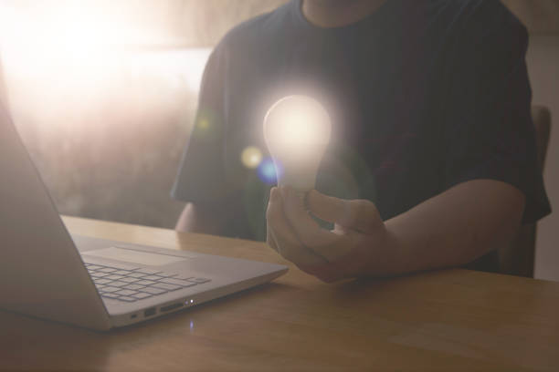 istock man hold light bulb lamp graphic  while use laptop computer in idea innovation power for solution and technology business concept 1418140905