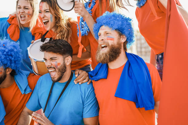 istock Crazy sport fans screaming while supporting their team - Focus on left guy face 1418143081