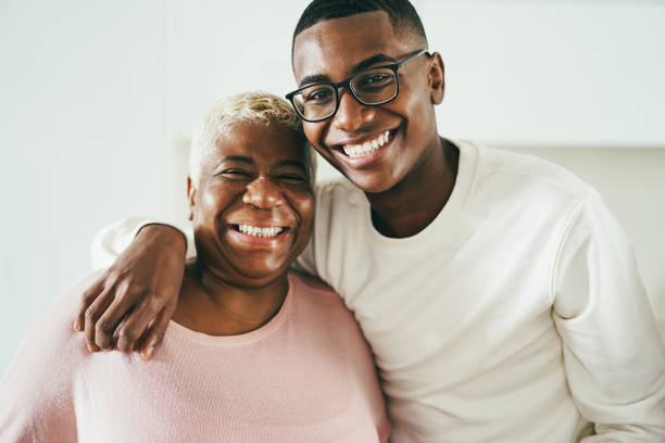 feliz madre e hijo africanos divirtiéndose abrazándose en casa - concéntrese en la cara de chico - 50 days old fotografías e imágenes de stock